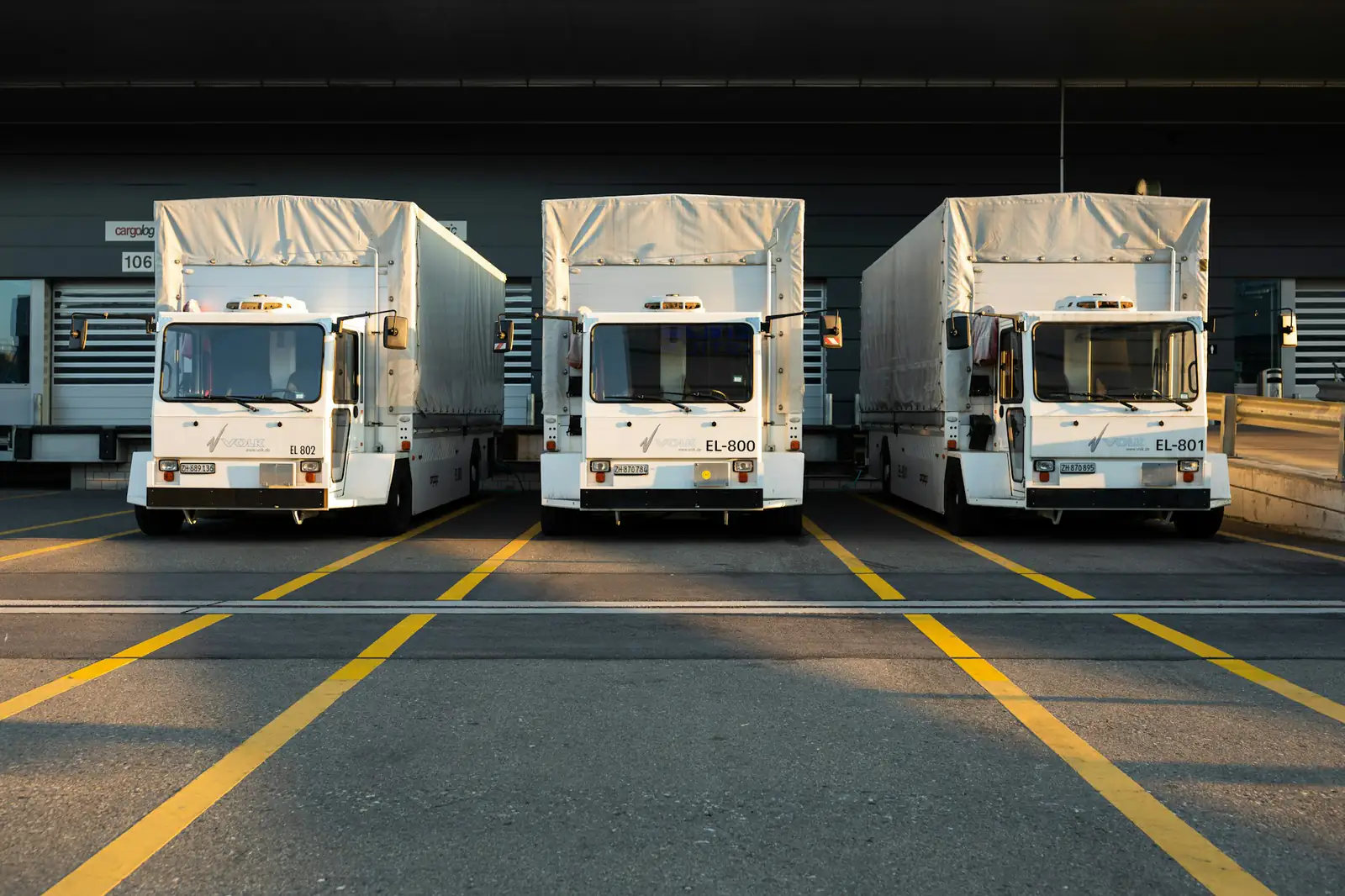 Row of delivery trucks parked at a depot
