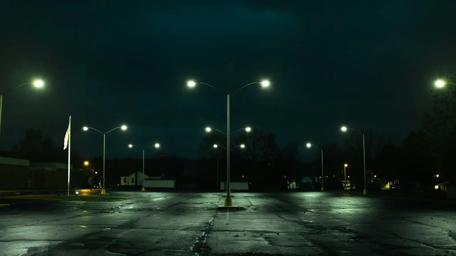 Empty parking lot at night under pole lights