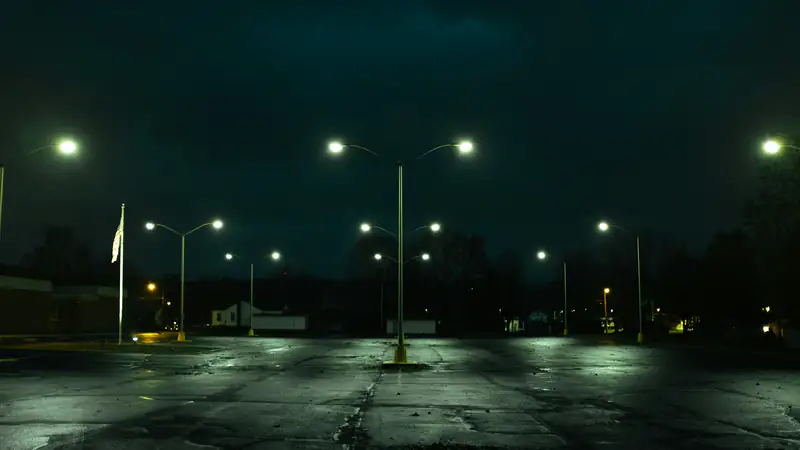 Empty parking lot at night under pole lights