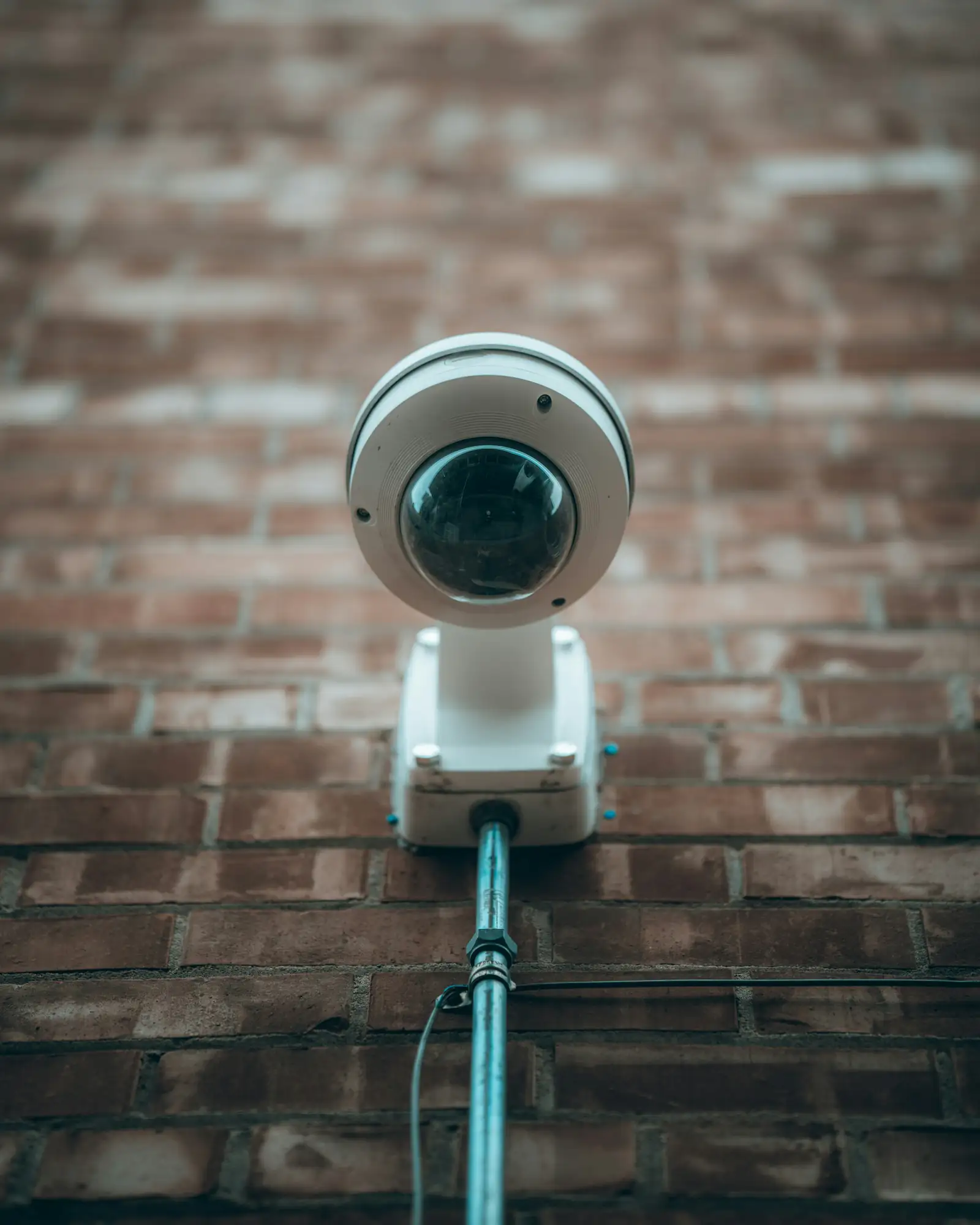 Dome security camera on a brick wall