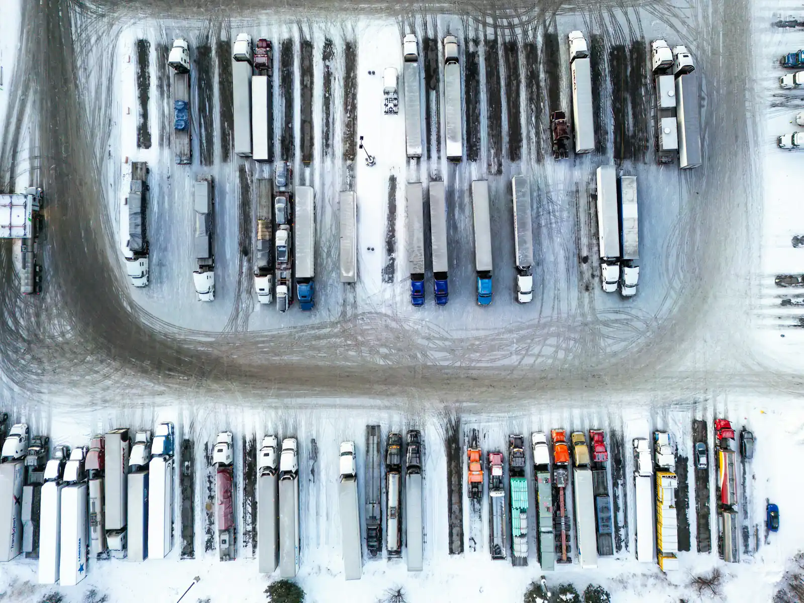 Aerial view of a truck yard full of parked trailers in winter